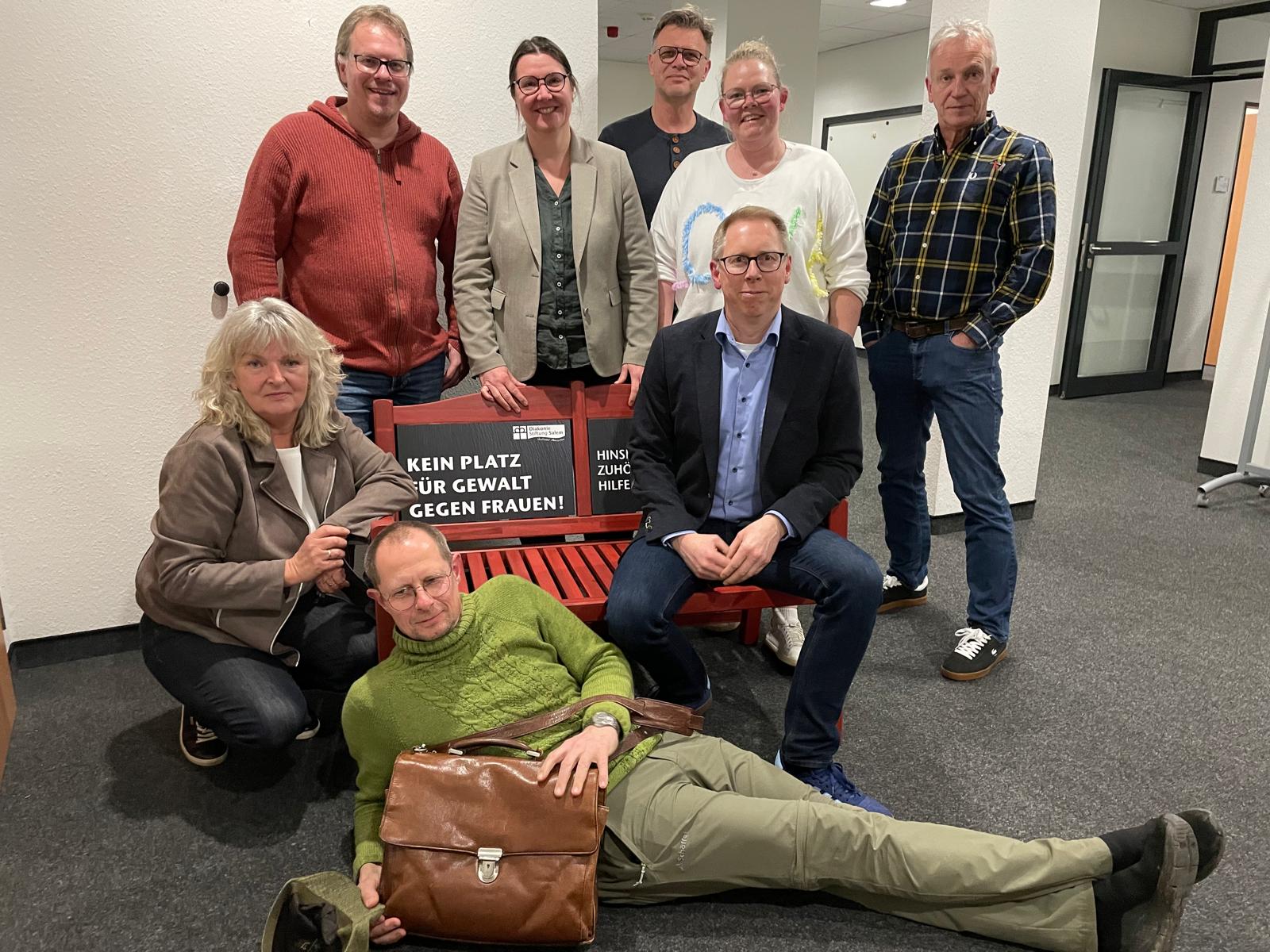 Anne Bösche, Tobias Glombek, Dr. Sylvia Arnold, Martin Seehafer, Tanja Brune, Marc, Weber, Horst Wehage und Klaus Becker mit der roten Bank gegen Gewalt an Frauen